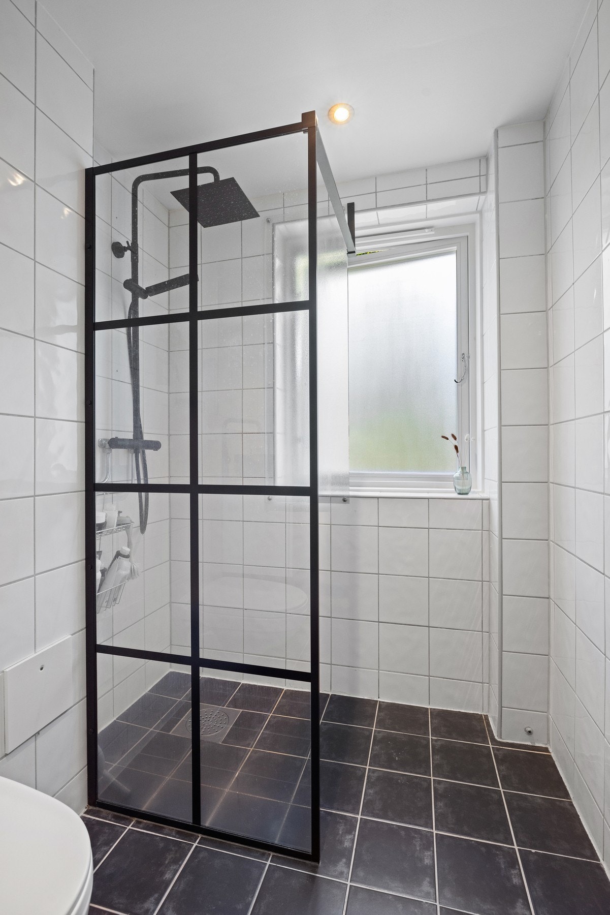 Badet er utstyrt med toalett og dusjhjørne med fastmontert dusjvegg. Galleribilde