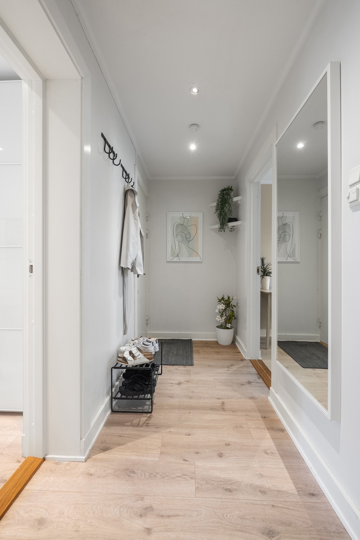 Gulvet i entréen er belagt med laminat som gir en gjennomført og stilren helhet, mens veggene er holdt i en lys og delikat fargetone. Galleribilde