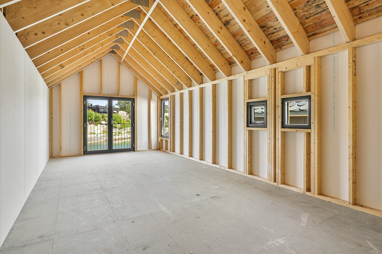 Ett stort og to mindre vindu som slipper dagslys inn i naustrommet Galleribilde