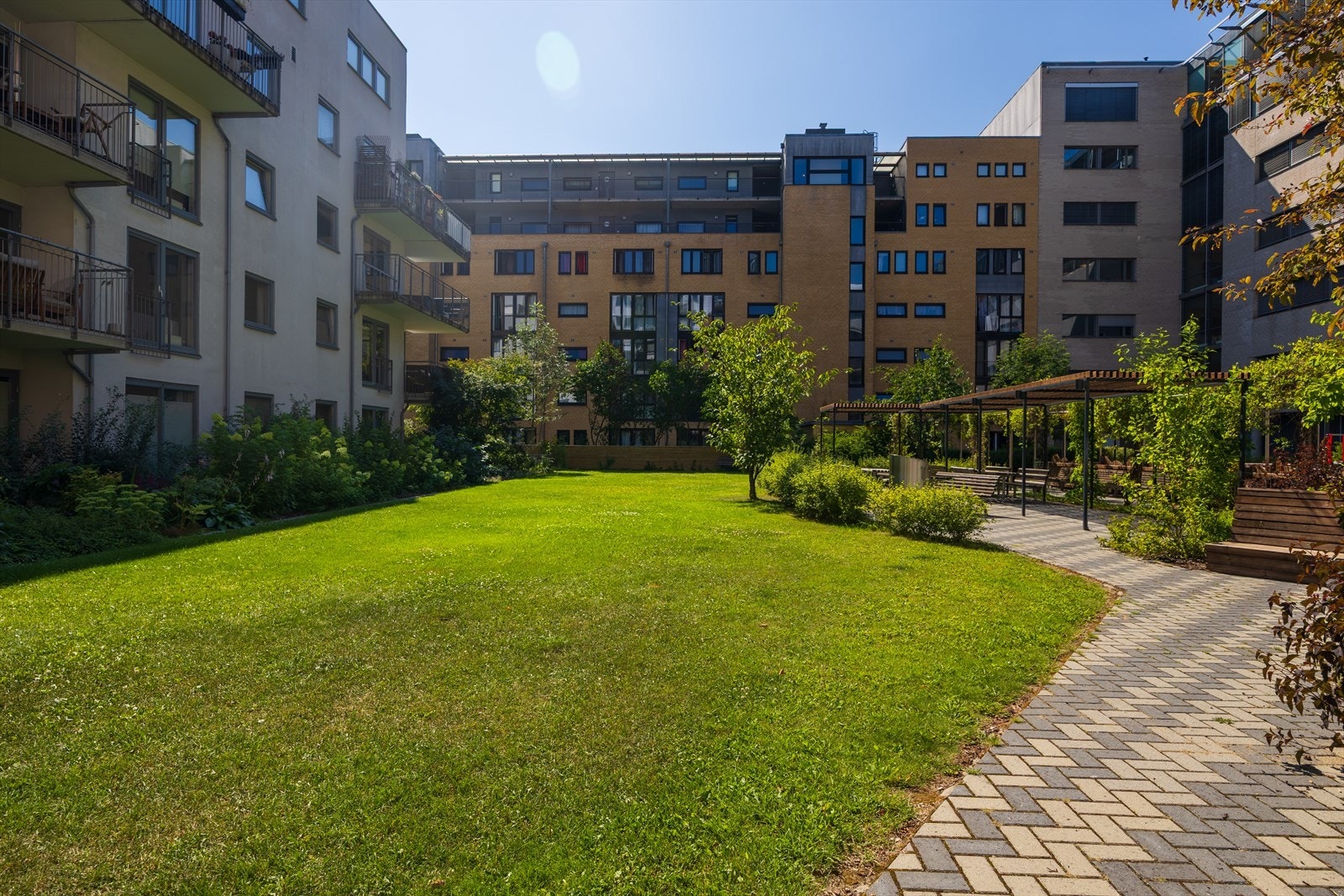 Et innbydende grøntareal med gressflekk som gir liv til fellesområdene. Galleribilde