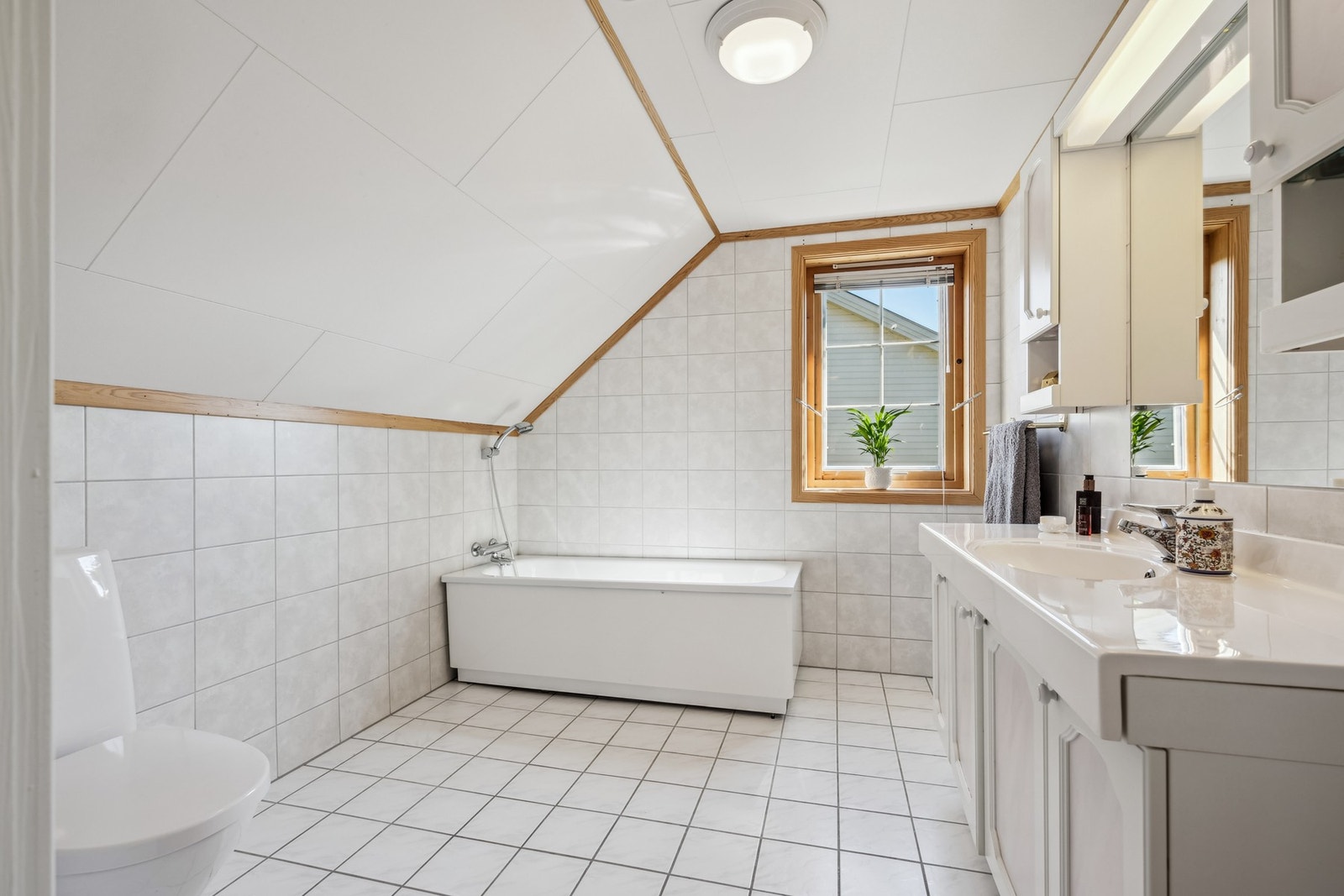 Bade ter innredet med badekar, stående klosett, servant og speil. Galleribilde