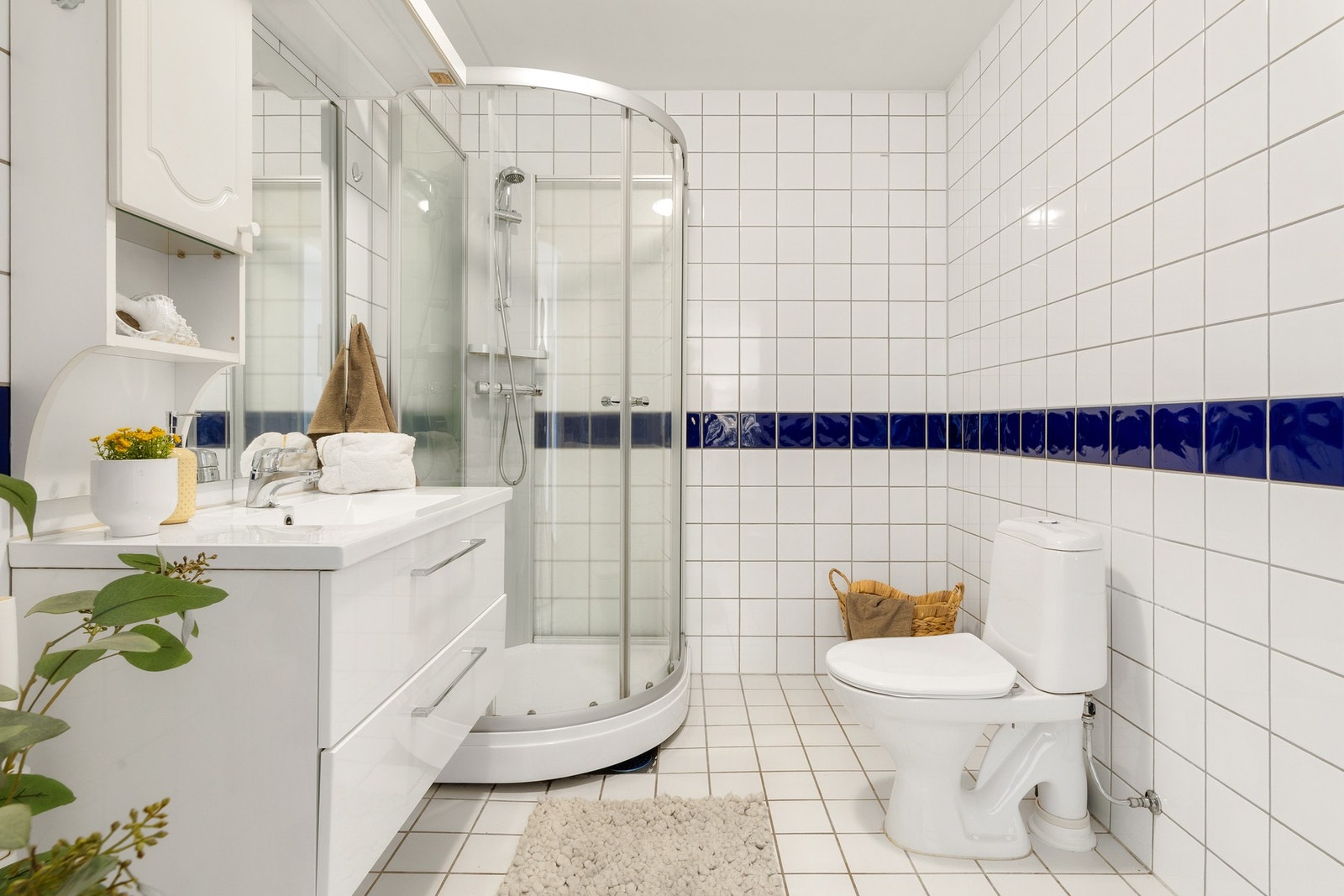 Klassisk, flislagt bad med gulvvarme og opplegg for vaskemaskin. Galleribilde