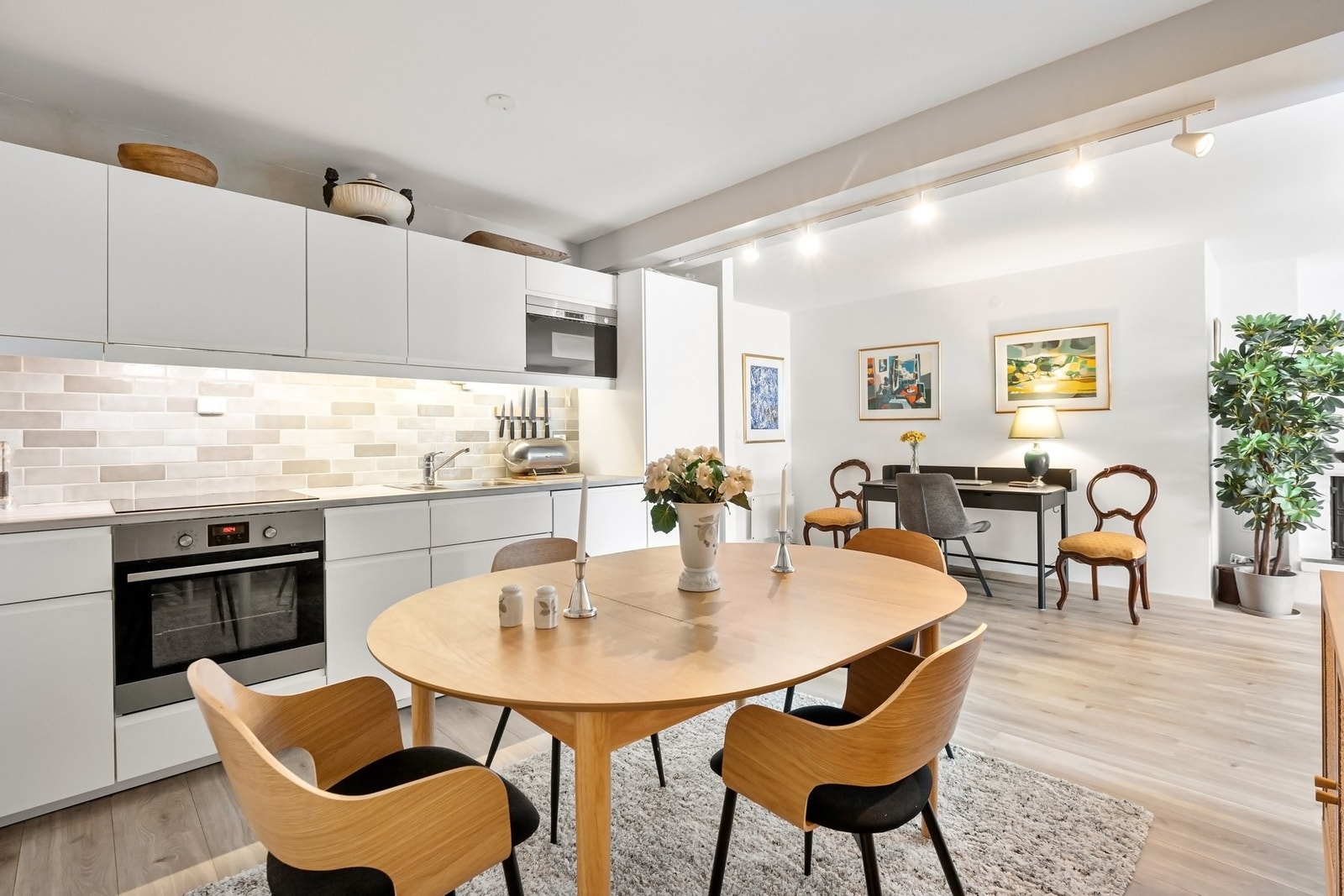 Kjøkken med integrert kjøleskap med fryser, oppvaskmaskin, mikrobølgeovn, stekeovn og induksjonstopp. Galleribilde