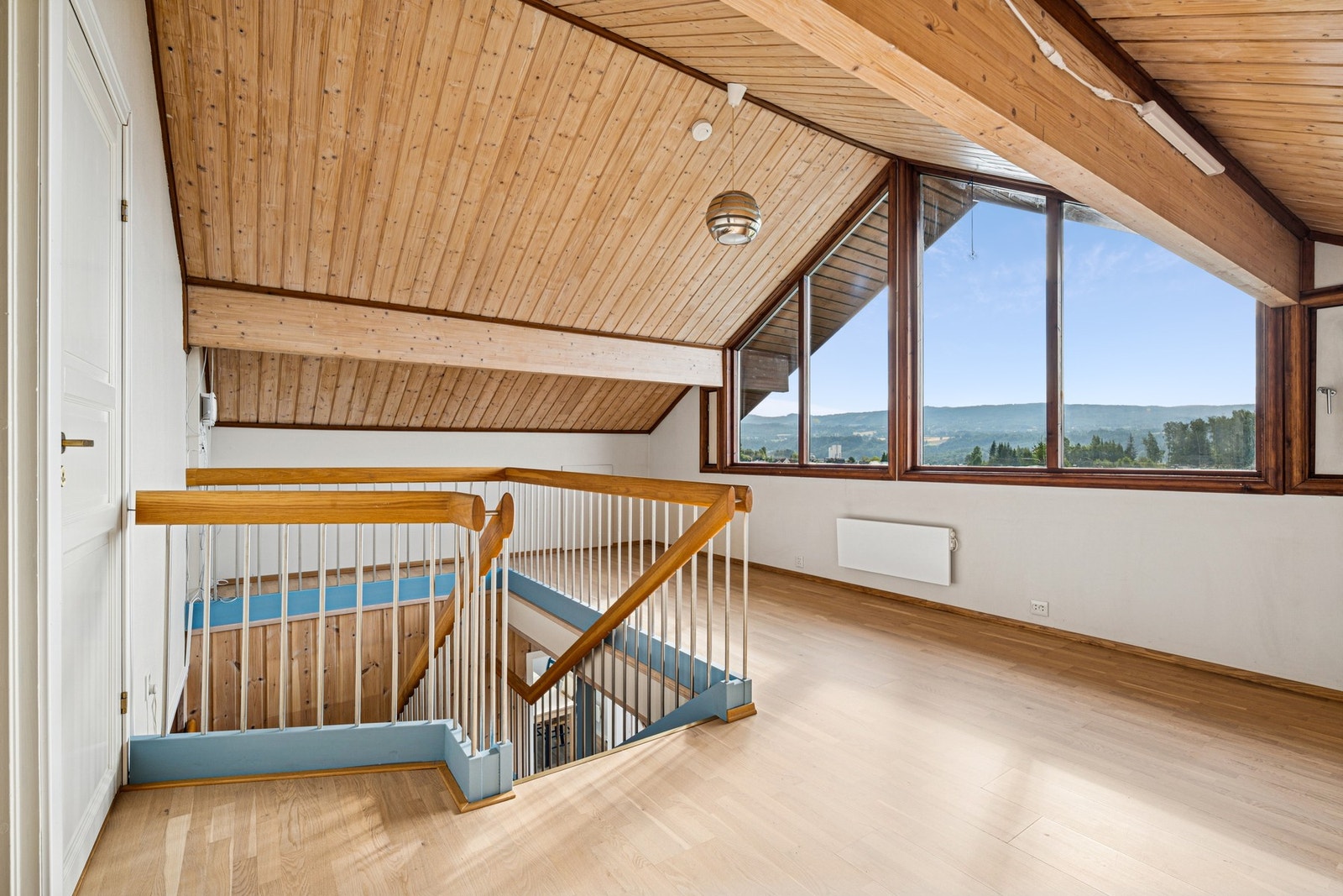 Romslig loftstue med skråtak og panoramavinduer som gir fantastisk utsyn over nabolaget og omkringliggende åser - et nydelig sted å trekke seg tilbake. Galleribilde