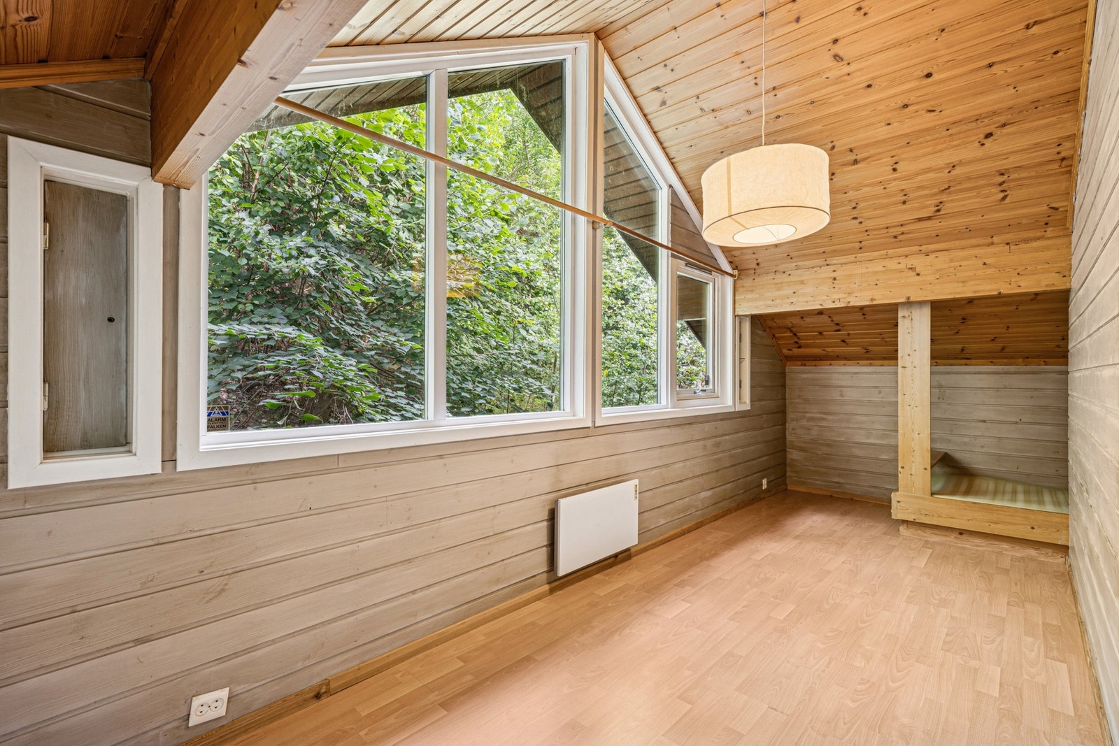 Svalt og sjarmerende soverom med synlige takbjelker, skråhimling og store vindusflater mot naturen - perfekt som barnerom, gjesterom eller hjemmekontor. Galleribilde