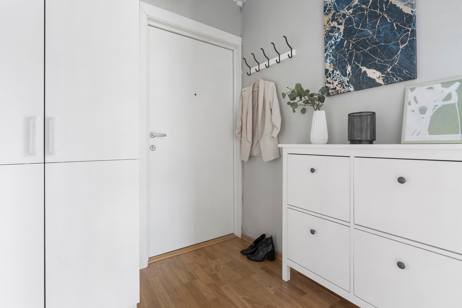 Entréen ønsker deg velkommen med lyse overflater og parkettgulv som gir en lun og ryddig førsteinntrykk. Galleribilde