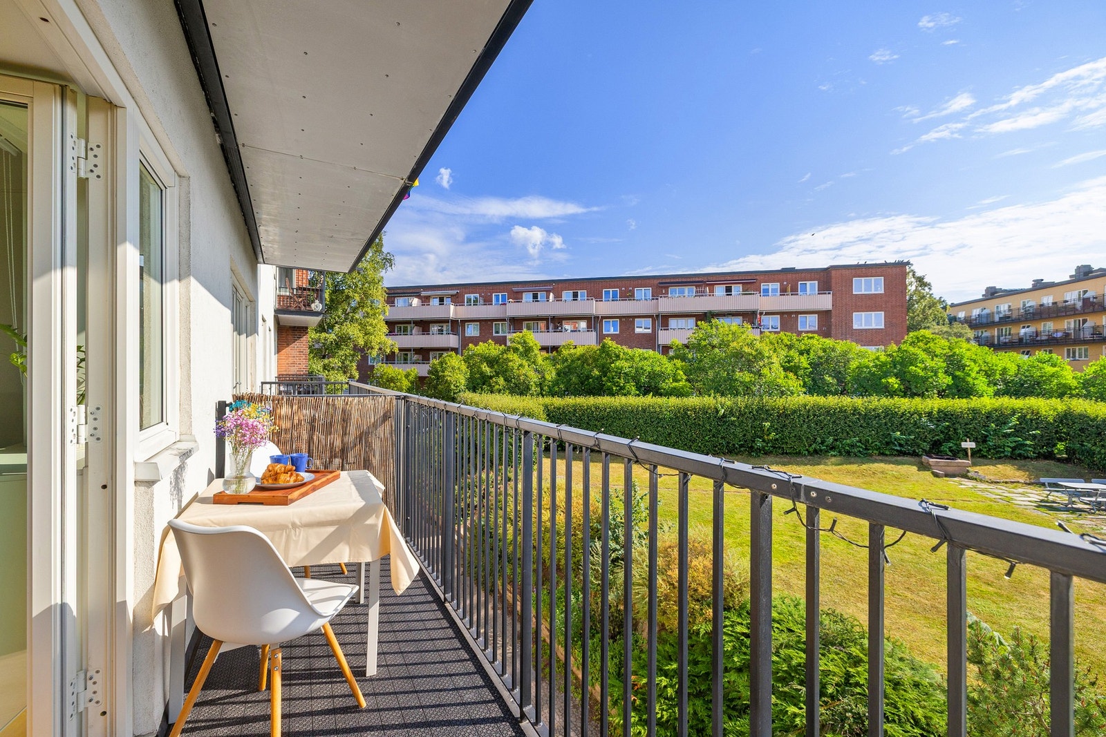 Balkongen er belagt med terrassebord og er omgitt av frodige grøntarealer. Galleribilde