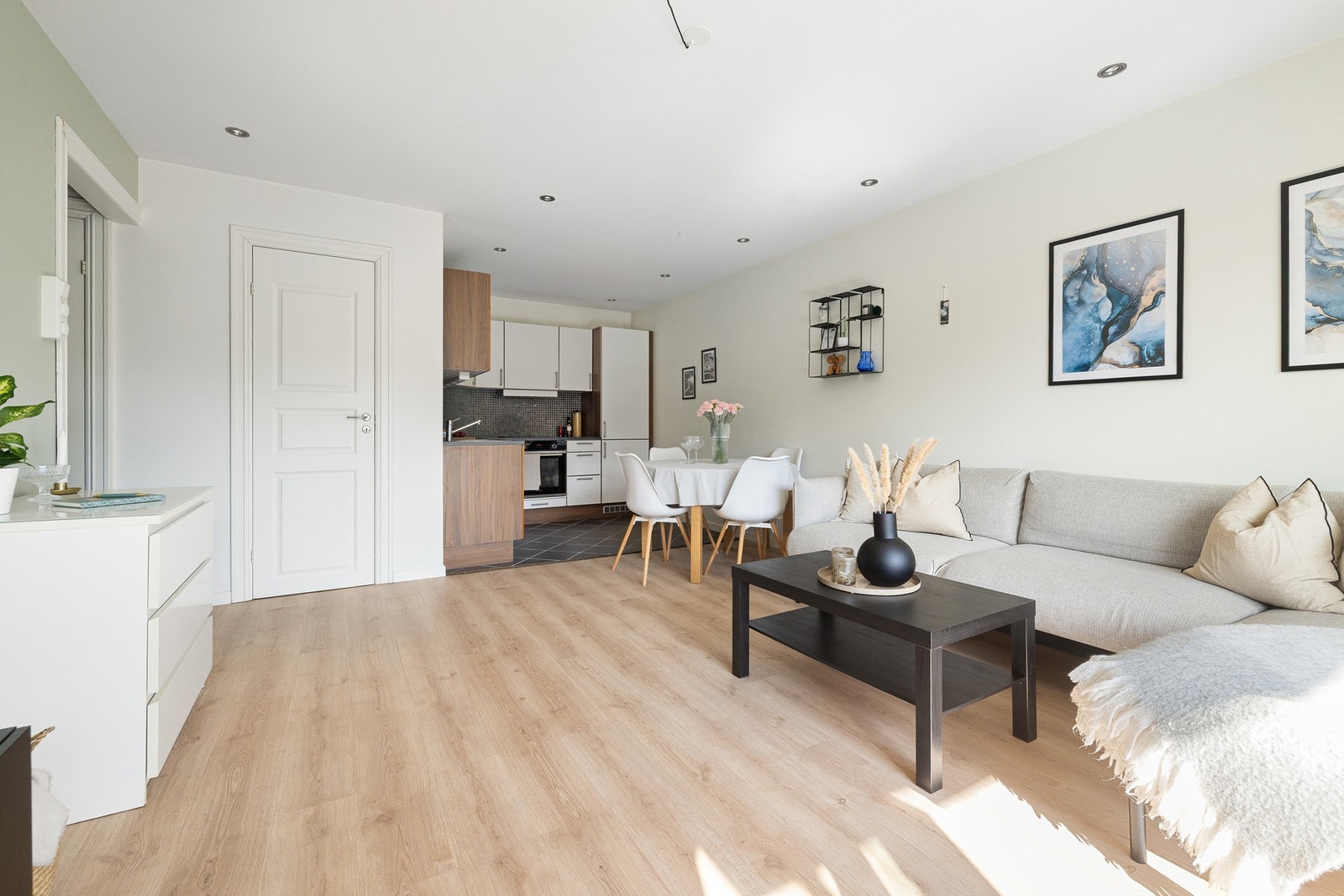 Stuen og kjøkkenet er gjort i en sosial og åpen løsning, men blir tydelig delt opp i to soner med kjøkkenkrok og stue Galleribilde