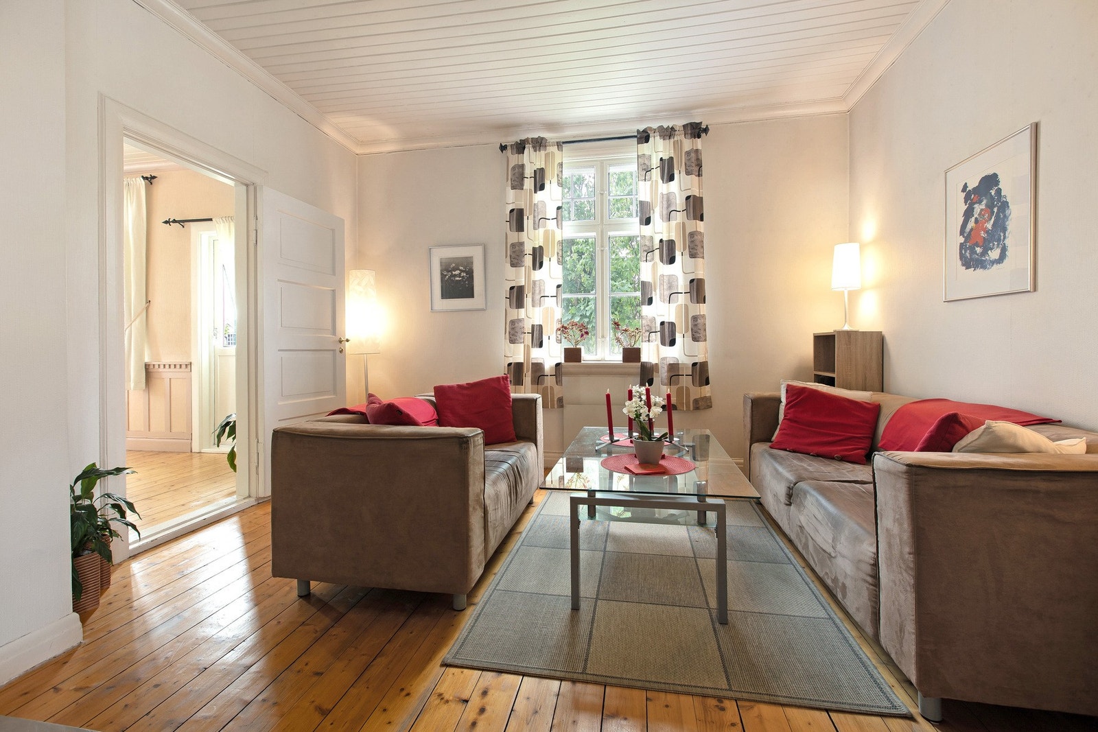 En av de tre stuene i 1. etasje med sofagruppe og tilhørende møbler. Galleribilde