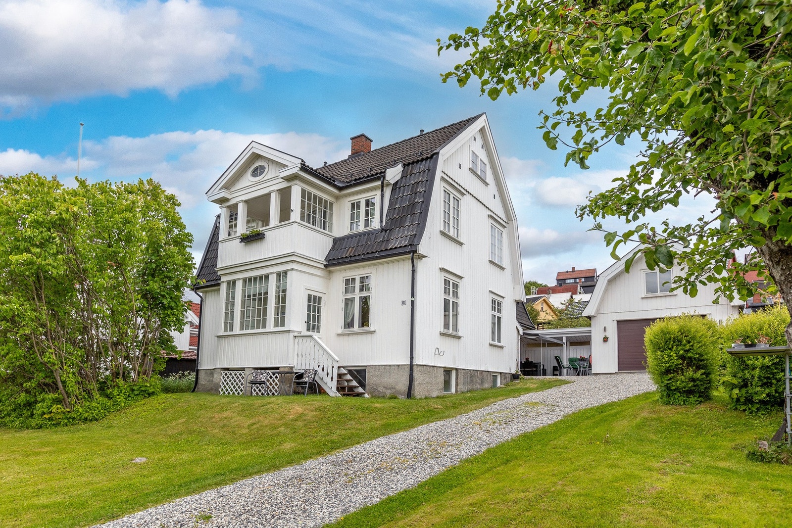 Flott og frodig eiet tomt med Gruset oppkjørsel og gårdsplass med biloppstillingsplasser. Galleribilde