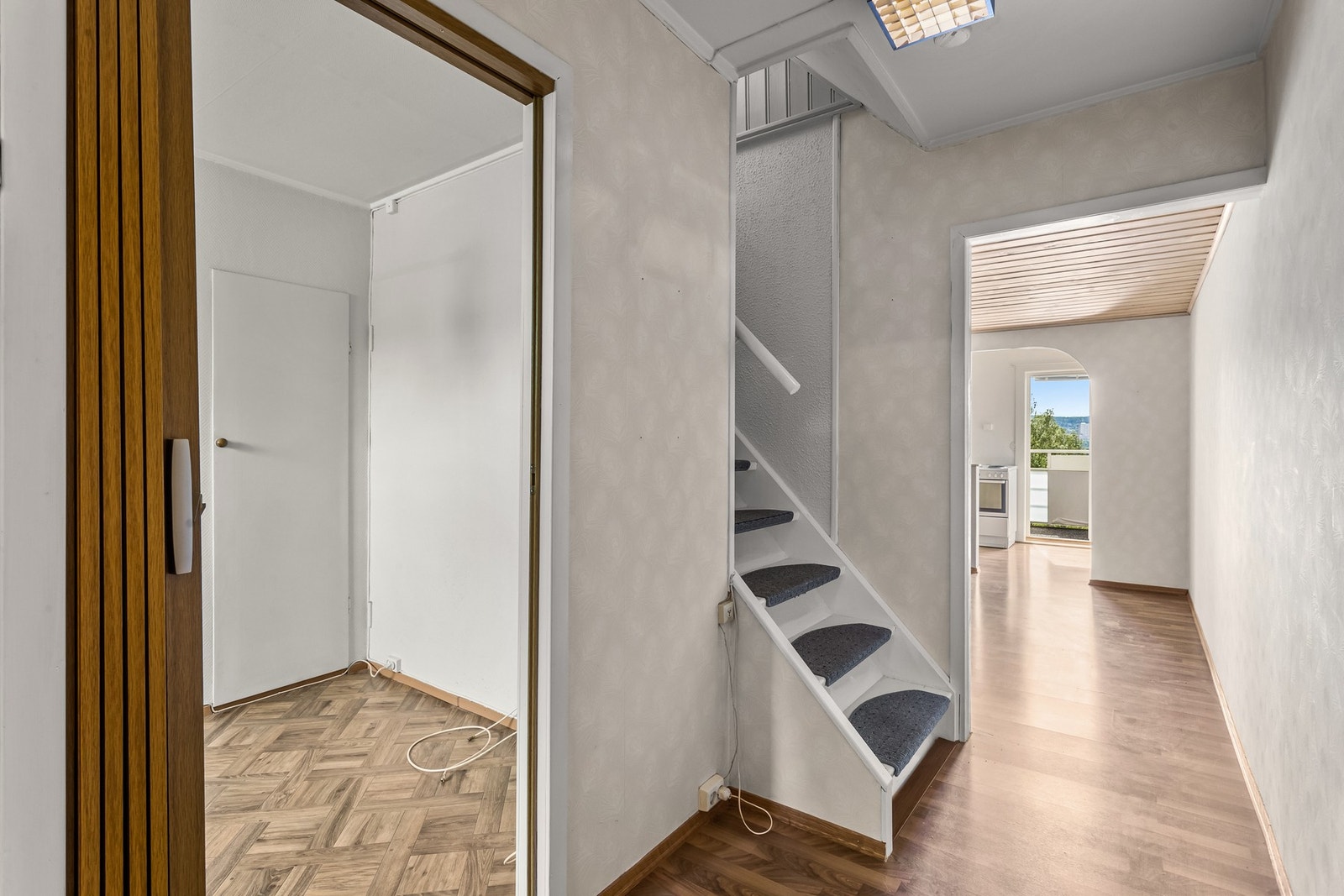 Lys gang med trapp til andre etasje og inngang til kjøkken. Galleribilde