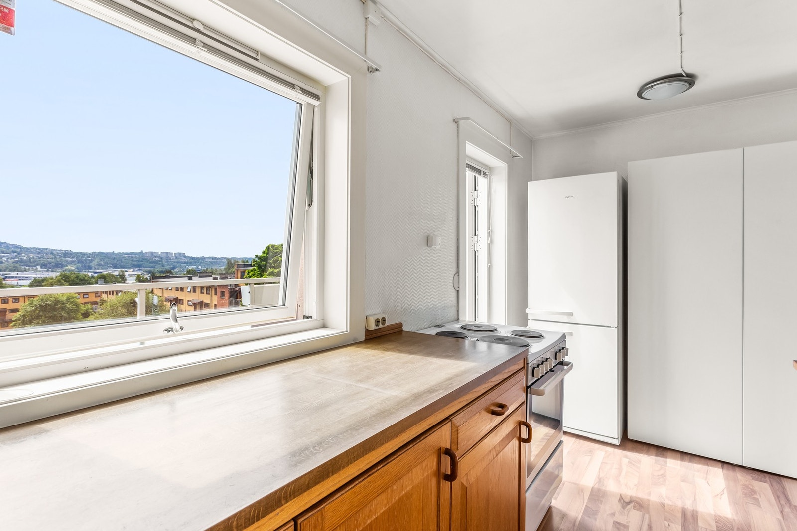 Kjøkkenet har en funksjonell utforming med laminert benkeplate mot vindu. Galleribilde