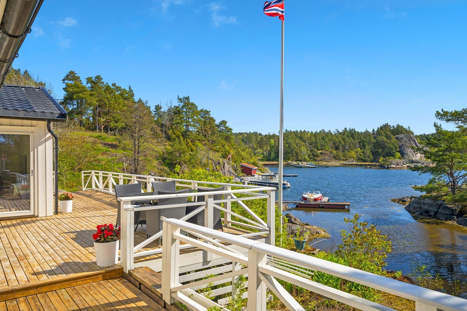 Stor uteplass på østsiden i form av veranda/terrasse, herfra har du herlig sjøkontakt med ca 10 lengdemeter og 3-4 høydemeter til sjøen. Galleribilde