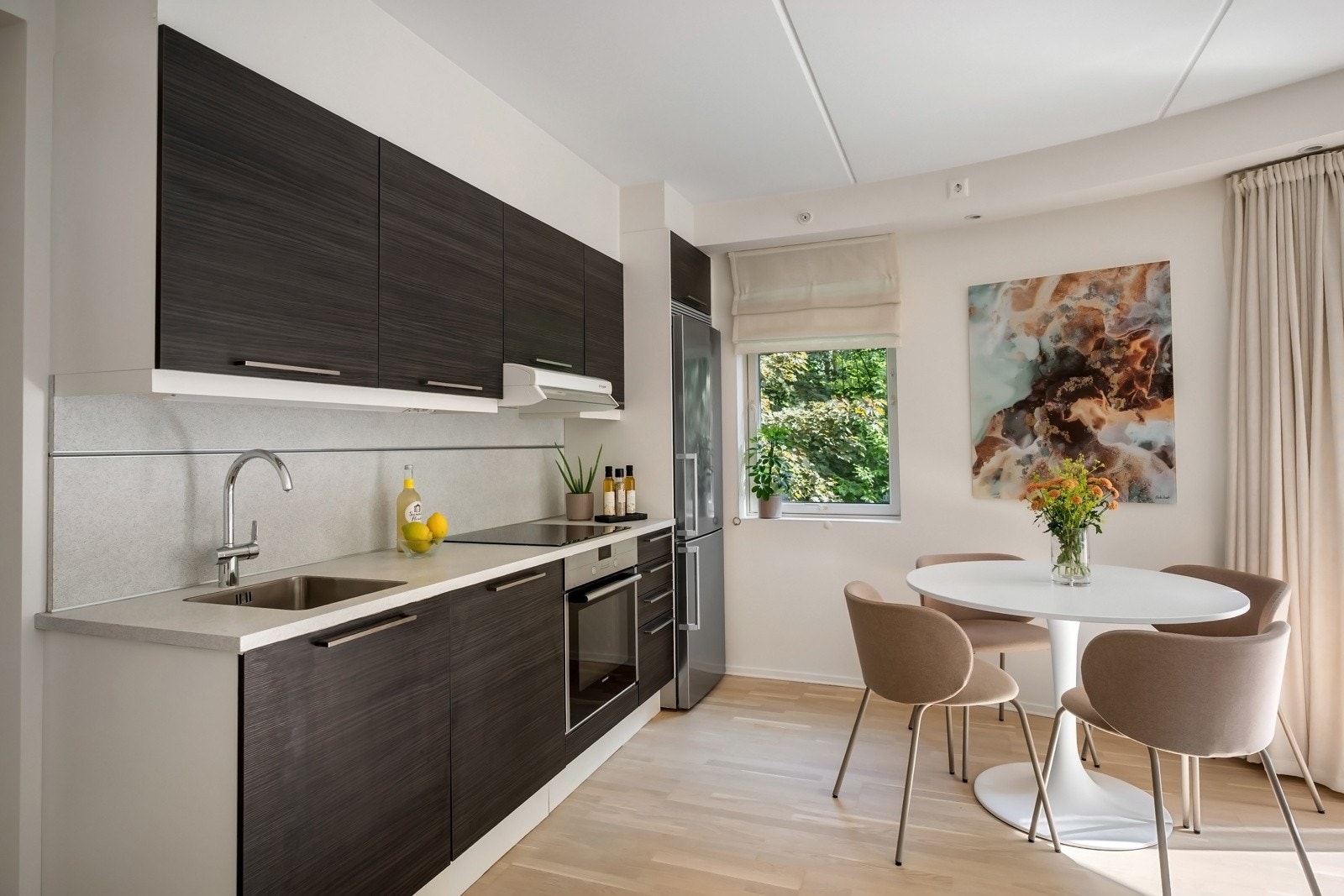 Vaskekummen er planlimt med nytt blandebatteri og en nyere induksjonstopp fra 2024 er felt ned i benken. Videre er det integrert stekeovn og oppvaskmaskin, samt ventilator og nisje til kjøleskap. Hvitevarer fra Siemens. Galleribilde