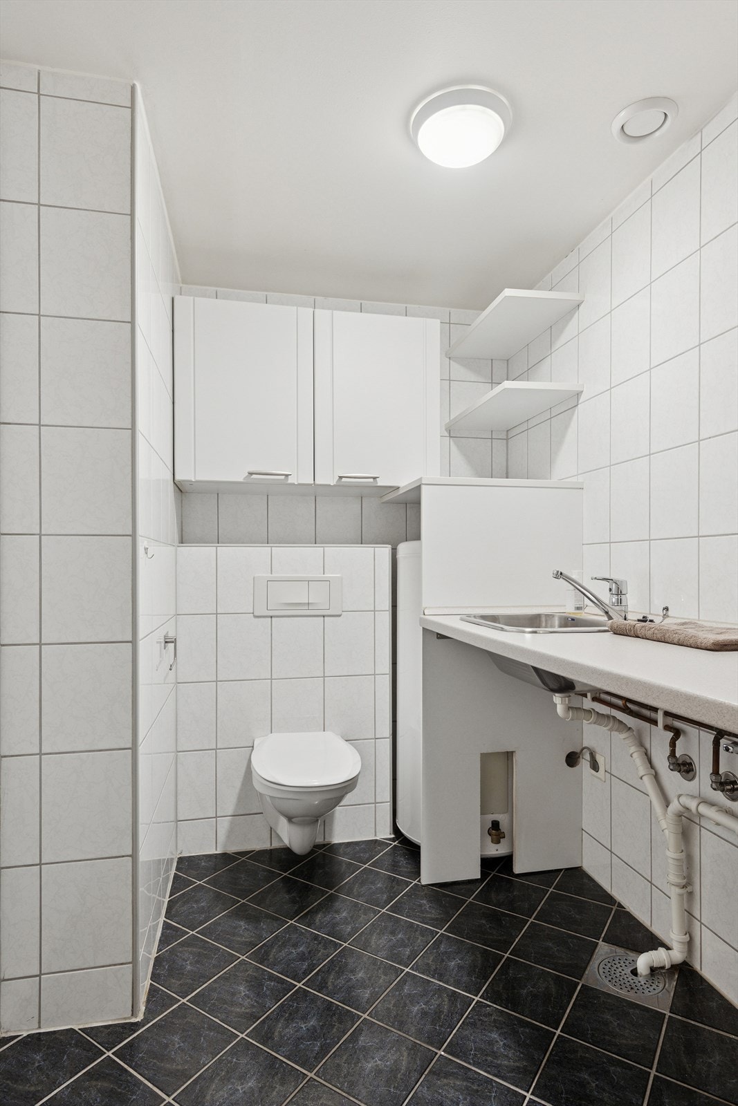 Praktisk med eget vaskerom, som er utstyrt med toalett og benkeløsning med opplegg til vaskemaskin. Galleribilde