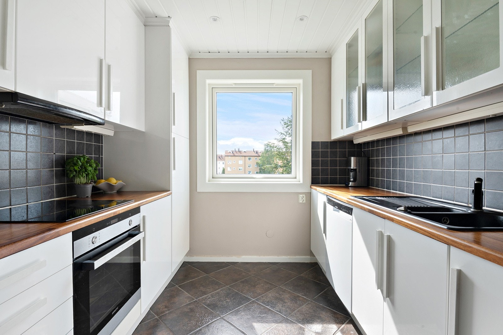 Kjøkkenet ligger adskilt fra stuen og fremstår som pent med rikelig benke- og skapplass. Galleribilde
