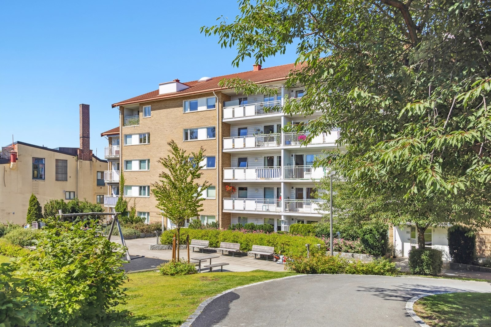 Pent opparbeidet fellesområdet med sittegrupper og diverse beplantning. Galleribilde