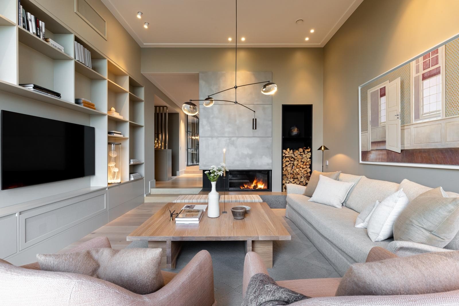 Stuen er innredet med plassbygd bokhylle i samme delikate fargetone som øvrige vegger. Galleribilde