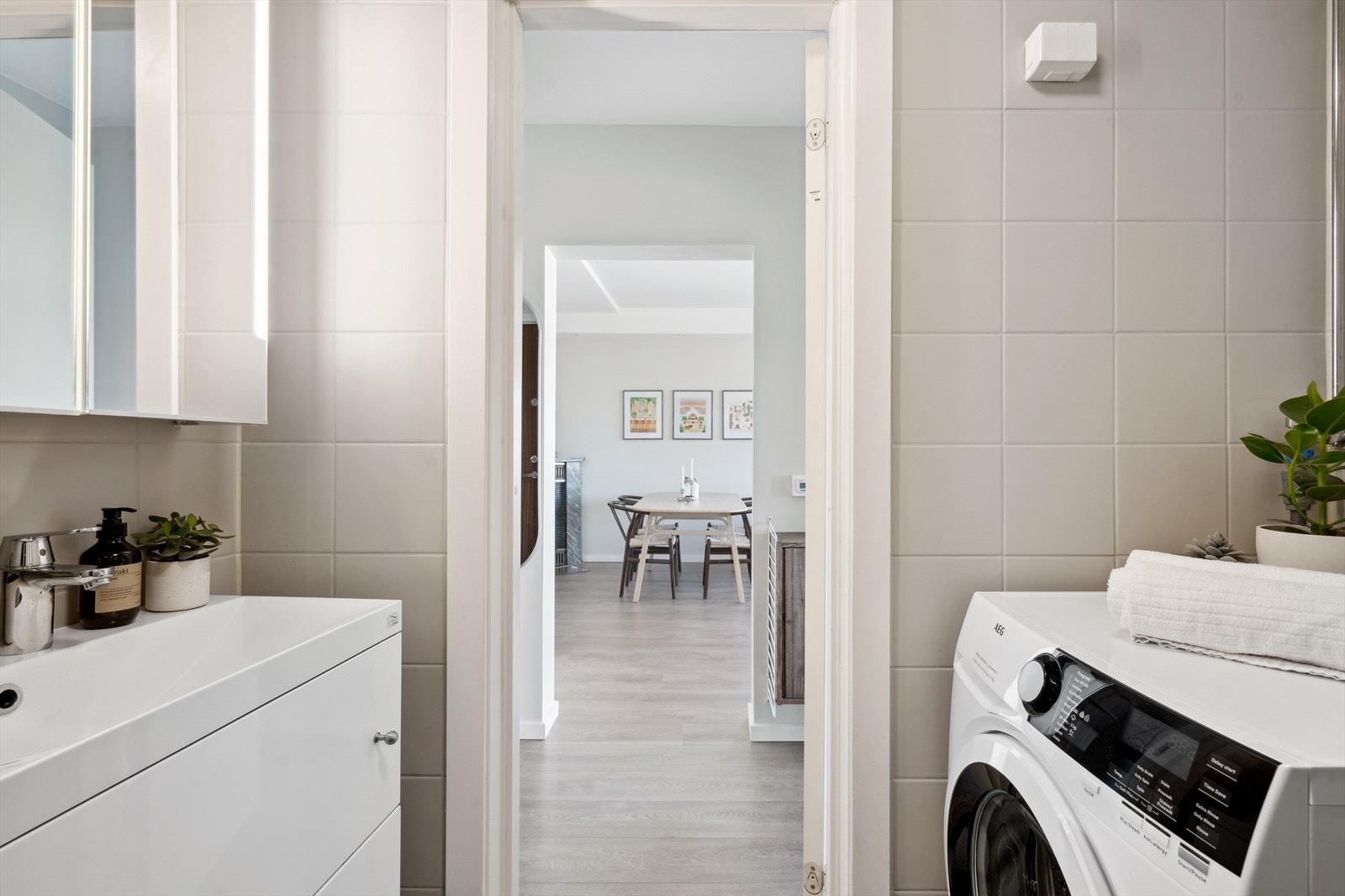 Innredningen består av vegghengt toalett, dusjnisje, servant med veggmontert skap og opplegg for vaskemaskin Galleribilde