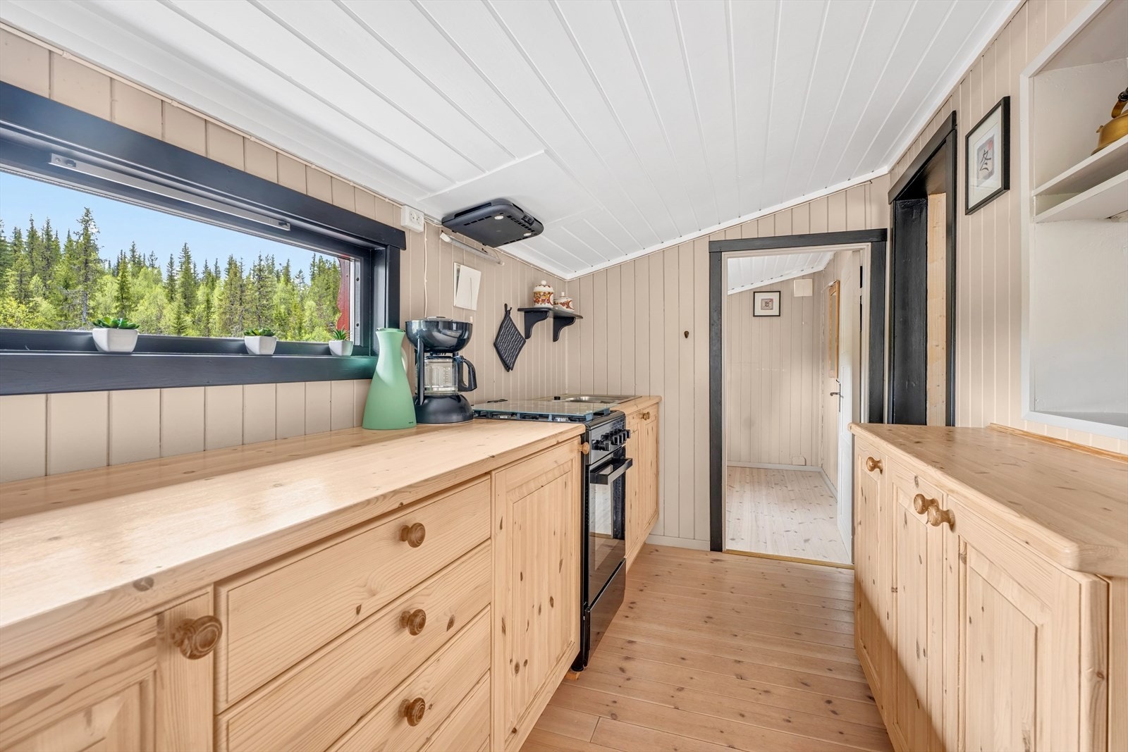 Hyttens kjøkken er tilbygget etter byggeår og har en heltre furu kjøkkeninnredning fra ca. 2010 med benkeskap. Galleribilde