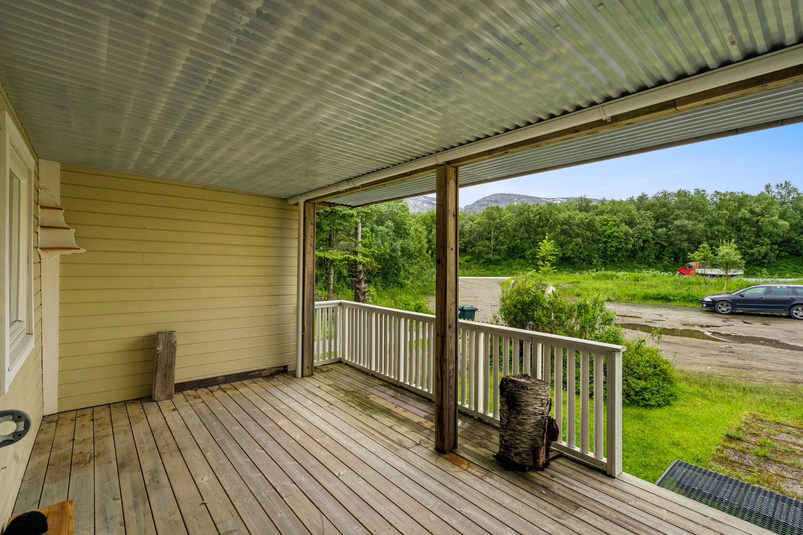 Overbygd inngangsparti med god plass til utemøbler - perfekt for hyggelige stunder ute, uansett vær Galleribilde