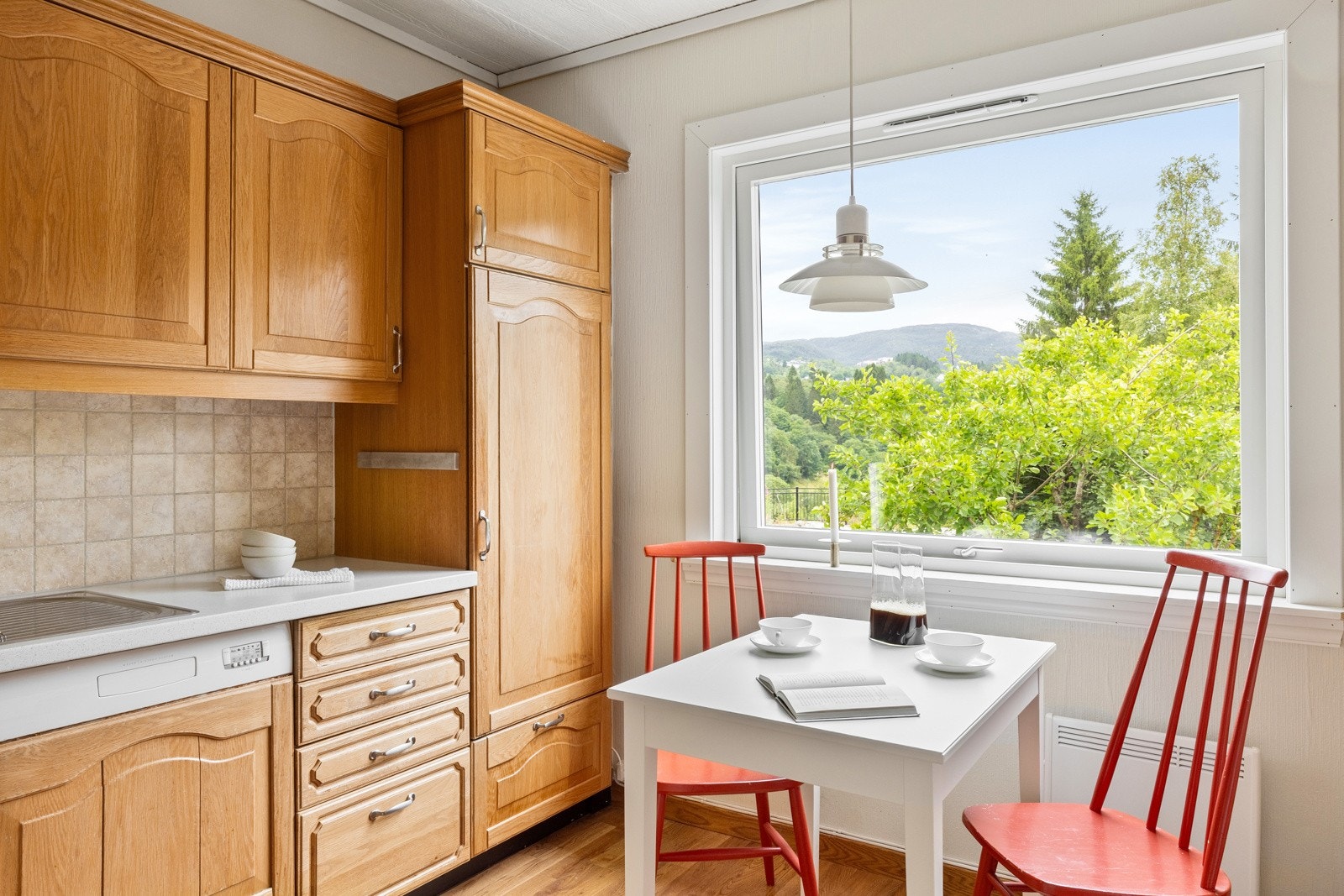 Kjøkkenet har profilerte fronter, laminert benkeplate og fliser over benk. Galleribilde