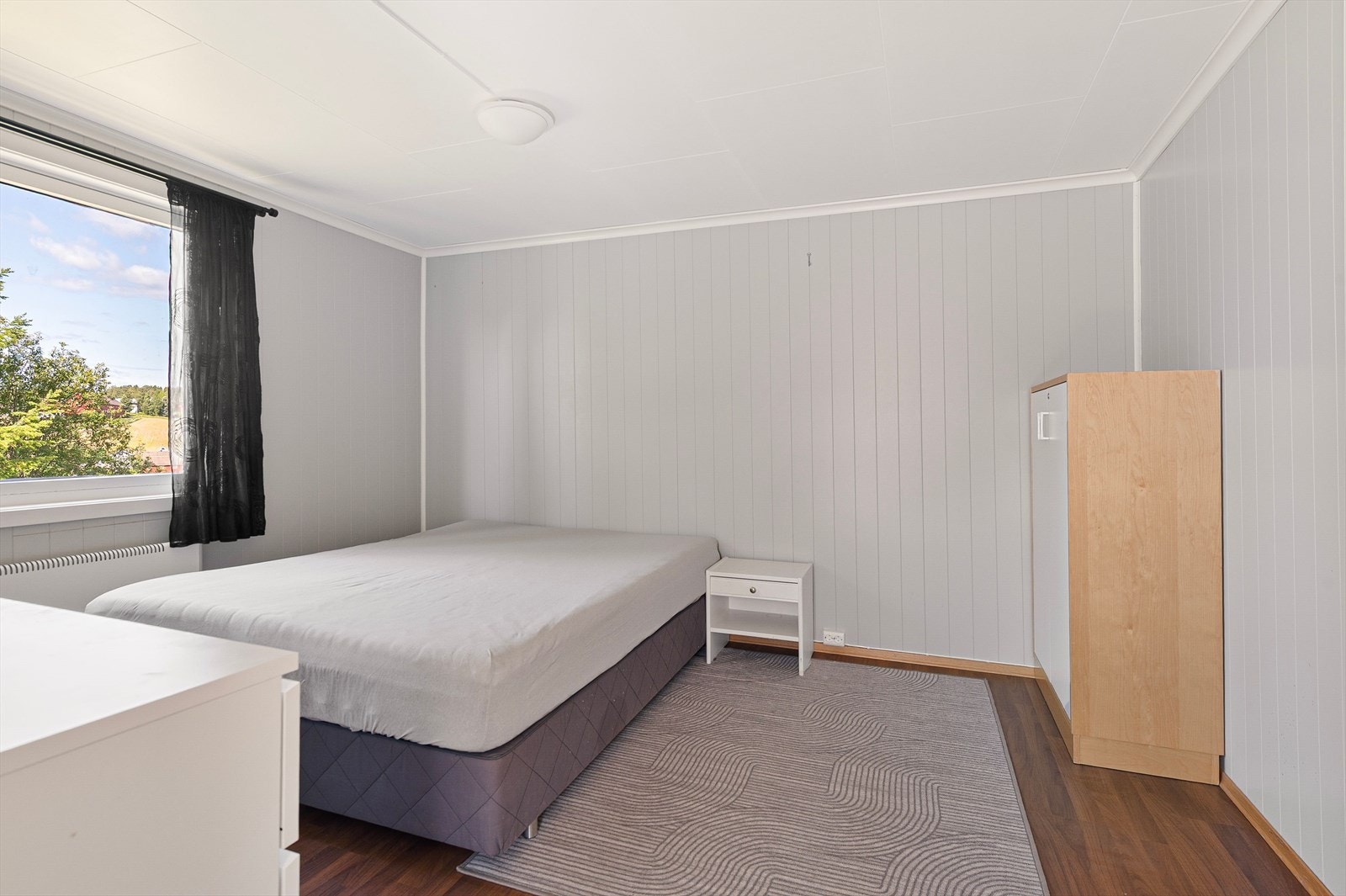 Lyst og stort hovedsoverom med hode møbleringsalternativer. Galleribilde