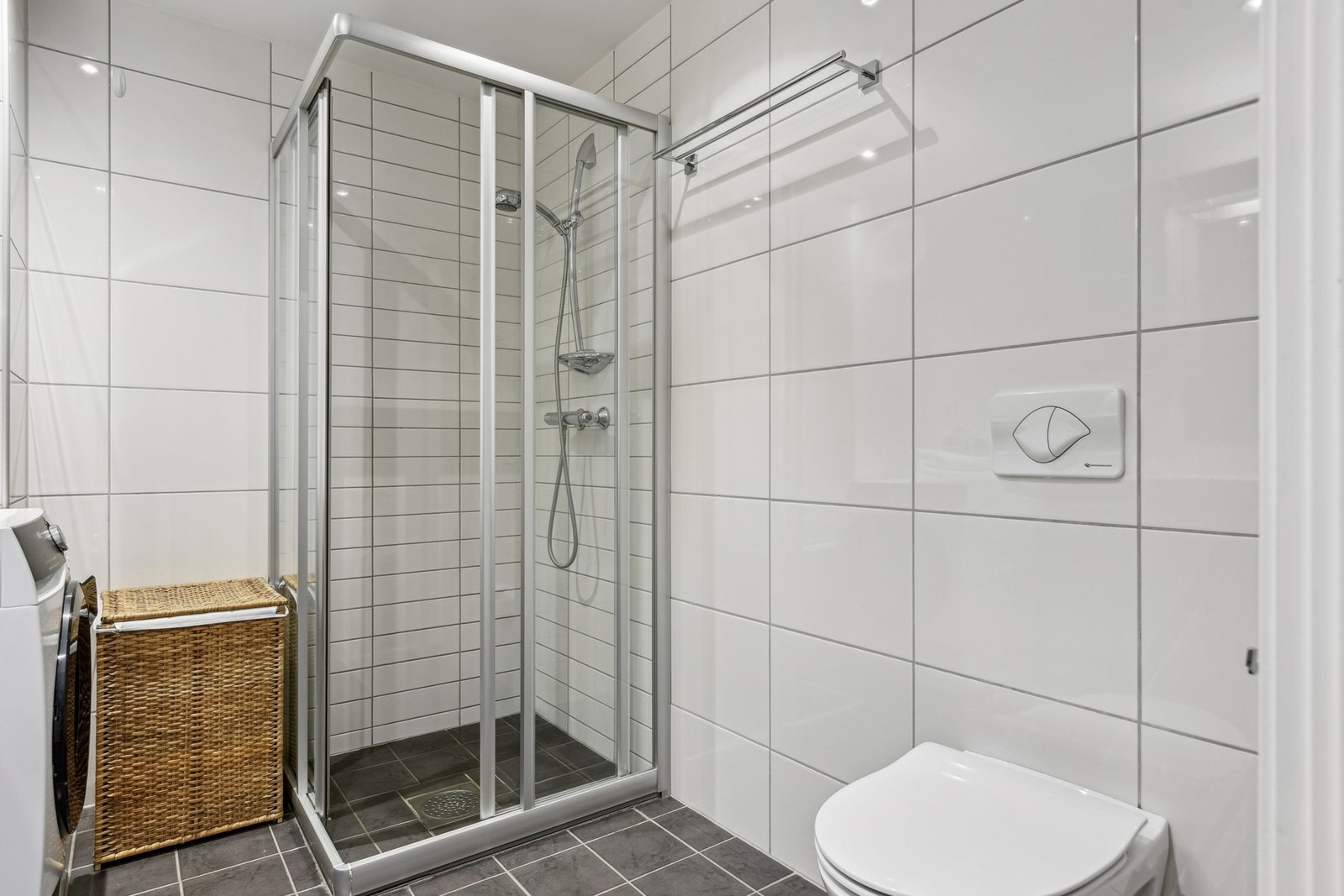 Baderommet har vegghengt servantinnredning, vegghengt toalett og dushjørne med dører. Galleribilde