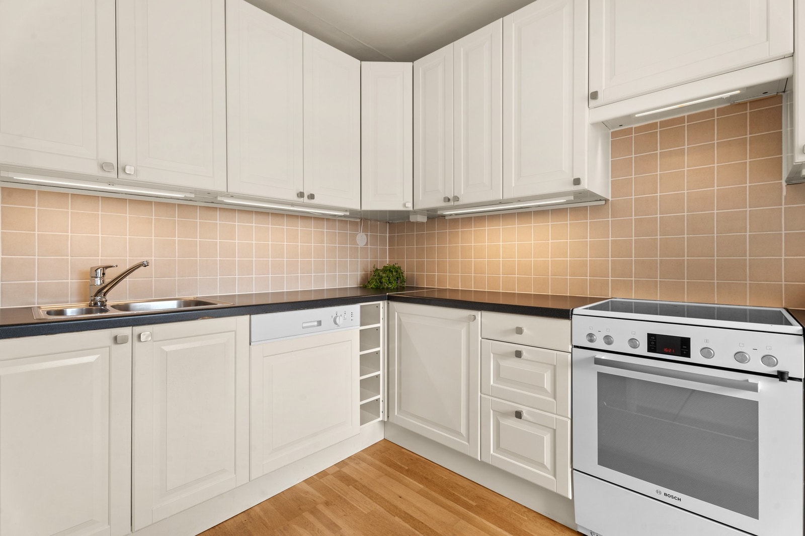 Innredningen har lyse, profilerte fronter, laminert benkeplate og nedfelt oppvaskkum. Oppvaskmaskin er integrert, og det er nisjer med plass til komfyr og kjøle/fryseskap. Galleribilde