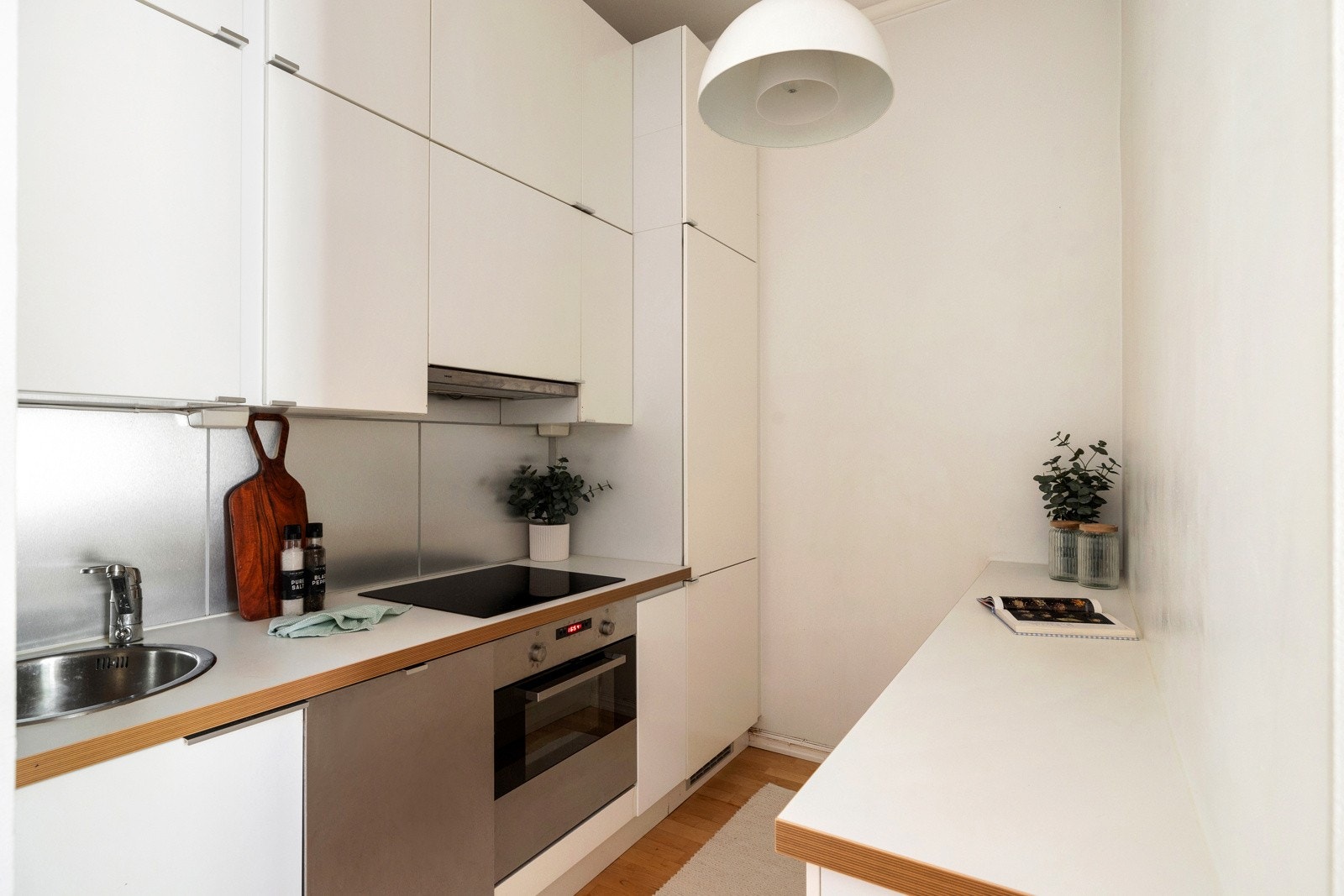 Kjøkkeninnredning fra 2011 med slette fronter og laminert benkeplate med nedfelt stålkum. Galleribilde