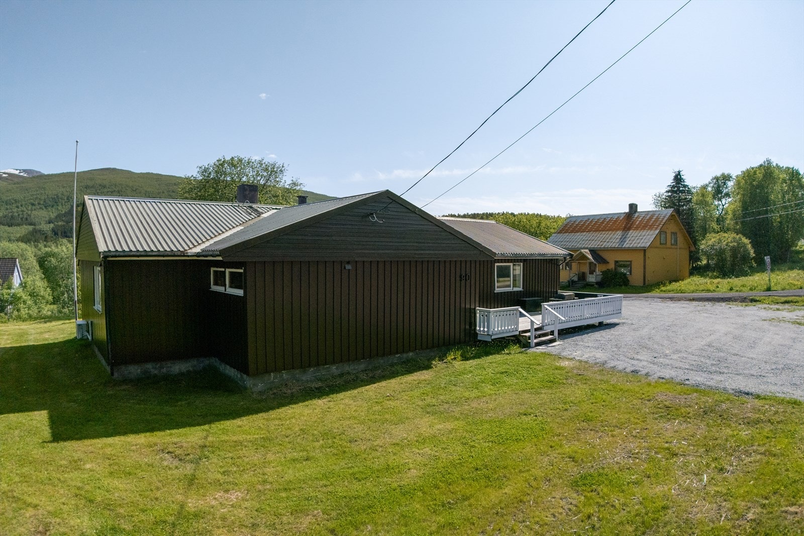 Flott uteareal med plen og stor parkering Galleribilde