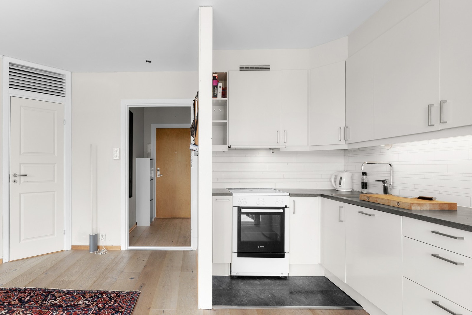 Over benken er det lagt hvite flisplater som backsplash og montert god benkebelysning. Galleribilde