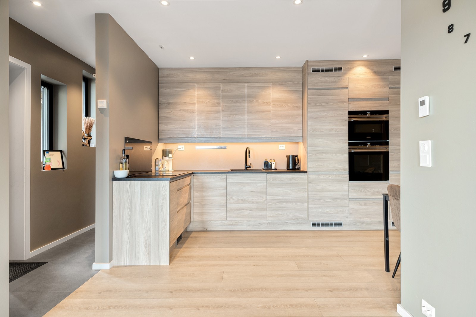 Lysere kjøkkeninnredning med integrerte hvitevarer Galleribilde