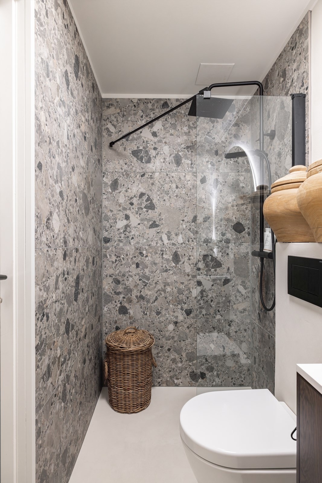 Baderommet har elektrisk gulvvarme og er innredet med vegghengt toalett, servant på møbel og dusjhjørne med glassvegg. Galleribilde