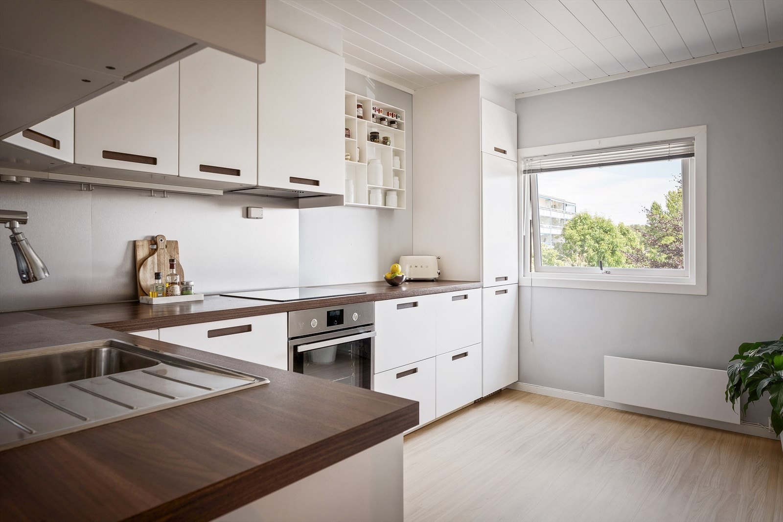 Lekkert kjøkken med innredning fra IKEA, glatte fronter og laminat benkeplate. Galleribilde