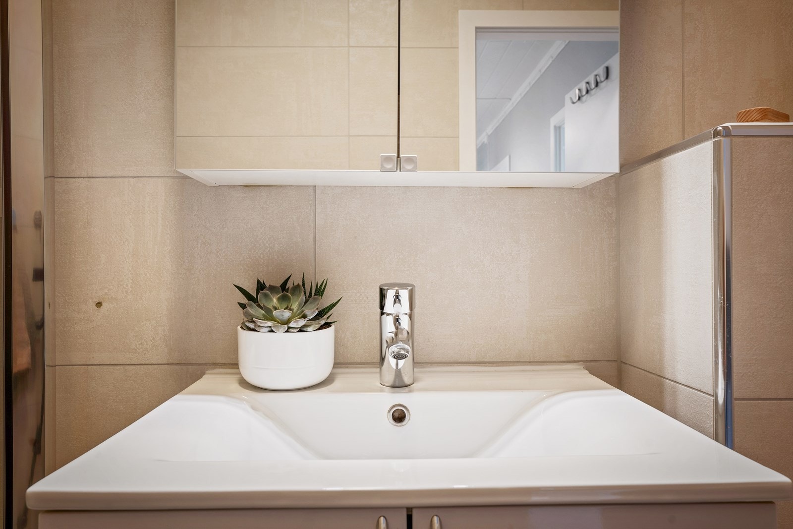 Innredningen består av vegghengt toalett, servant med speilskap og opplegg for vaskemaskin. Galleribilde