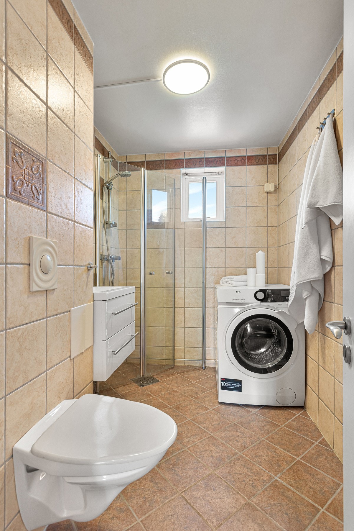 Flislagt bad med opplegg for vaskemaskin. Galleribilde