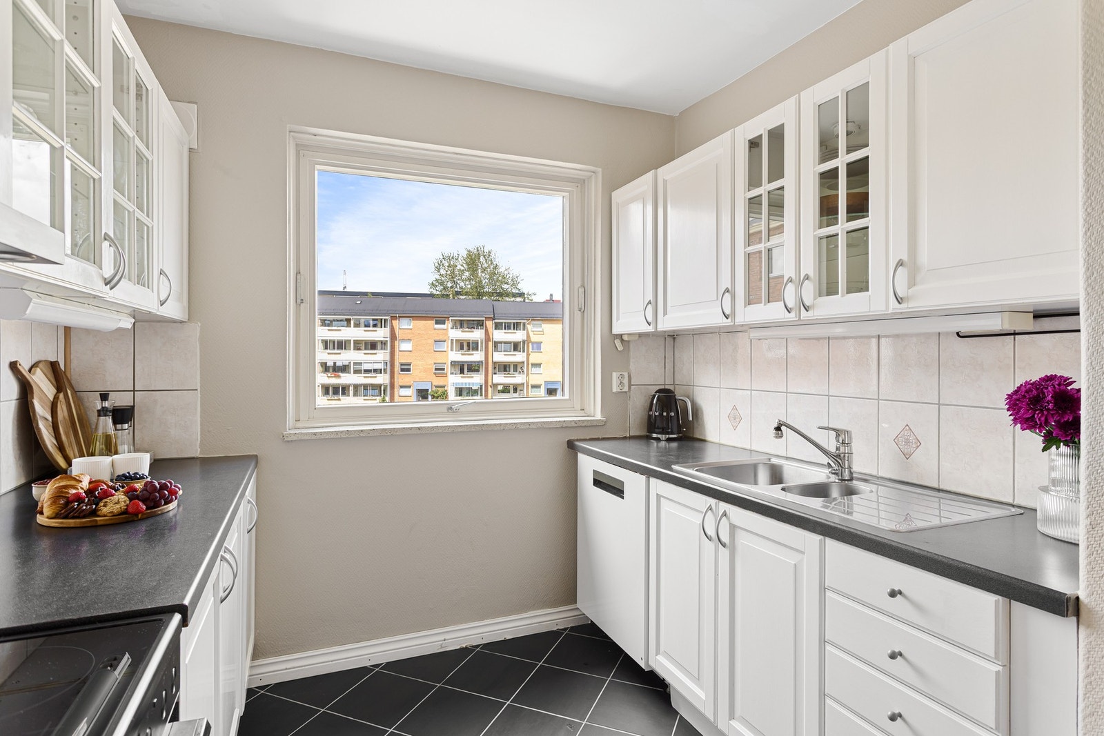 Lys, profilert innredning med laminat benkeplate og nedfelt oppvaskkum med ett-greps armatur. Galleribilde