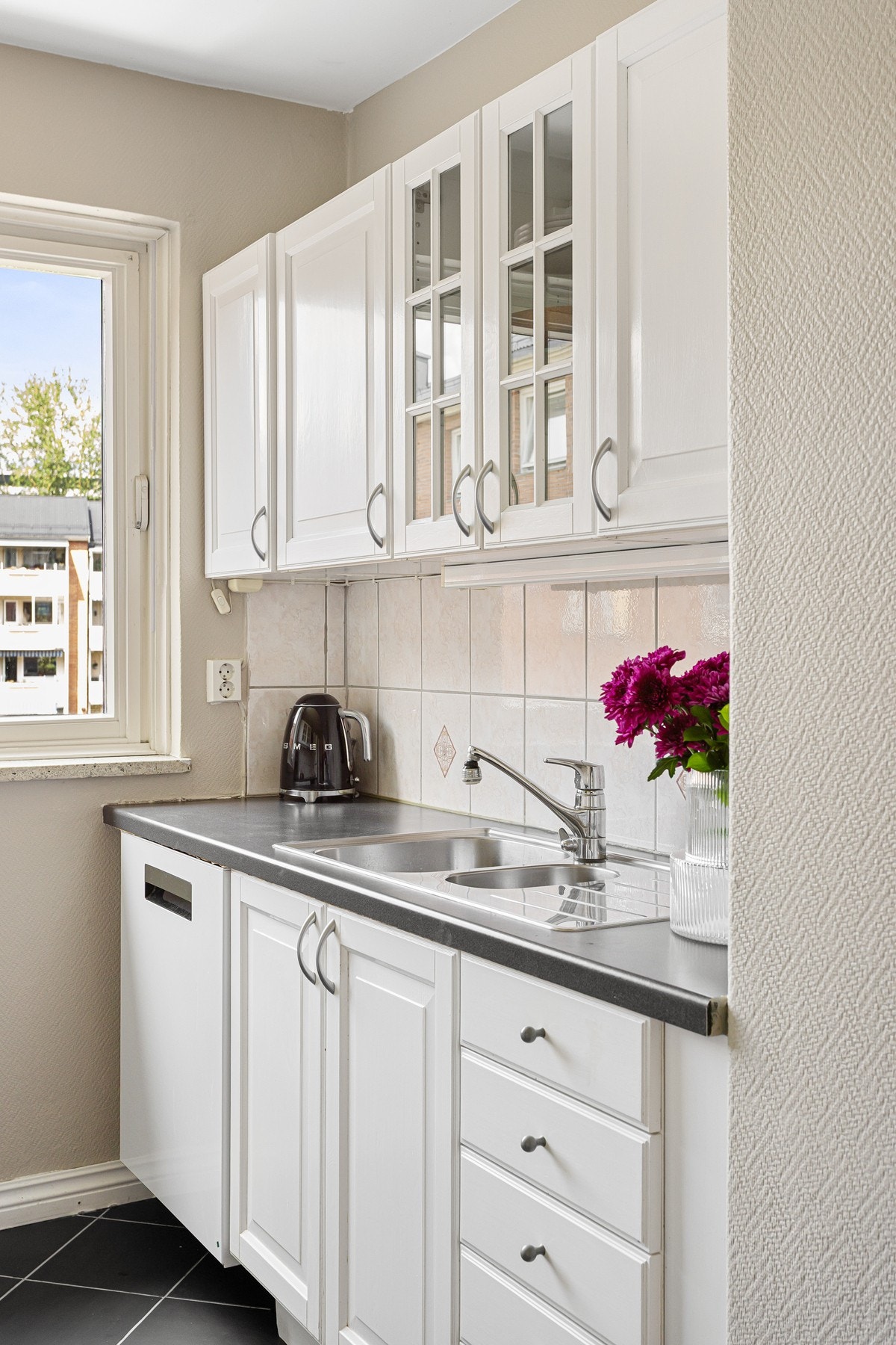 Det er lagt flisfelt over kjøkkenbenk, i tillegg til at det er montert belysning og stikkontakter under overskapene. Galleribilde