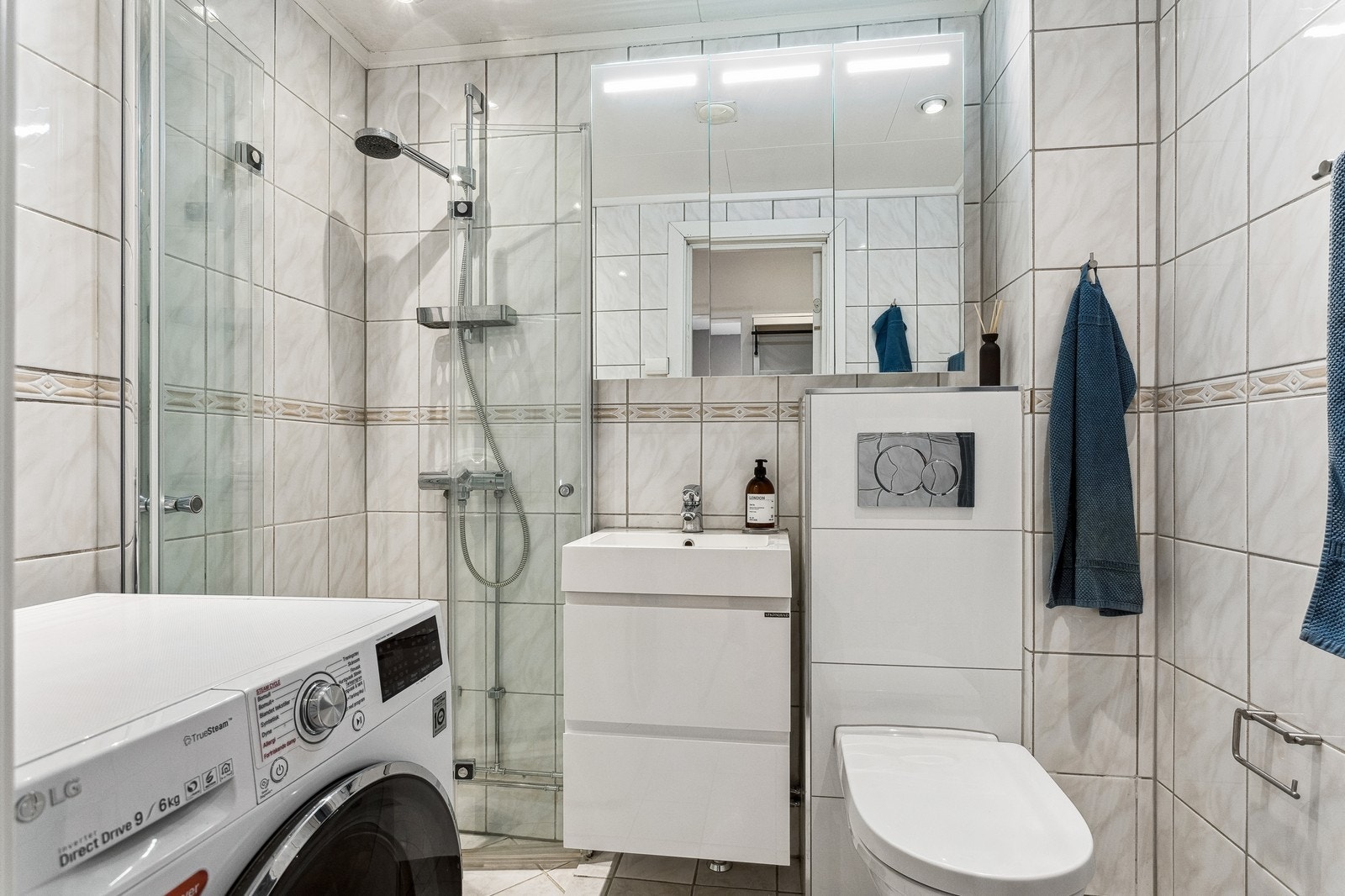 Flislagt bad med vaskemaskin. Galleribilde