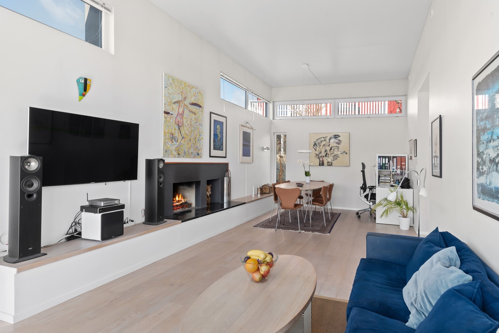 Stuen i 1. etg. Her er ekstra høyt under taket og en stilfull peisovn midt i rommet. Galleribilde