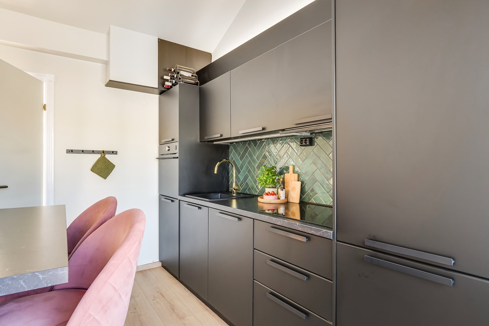 Det stilige kjøkkenet fra 2020 har elegante, svarte fronter og laminert benkeplate. Fliser over benkeplaten gir rommet et eksklusivt preg. Galleribilde