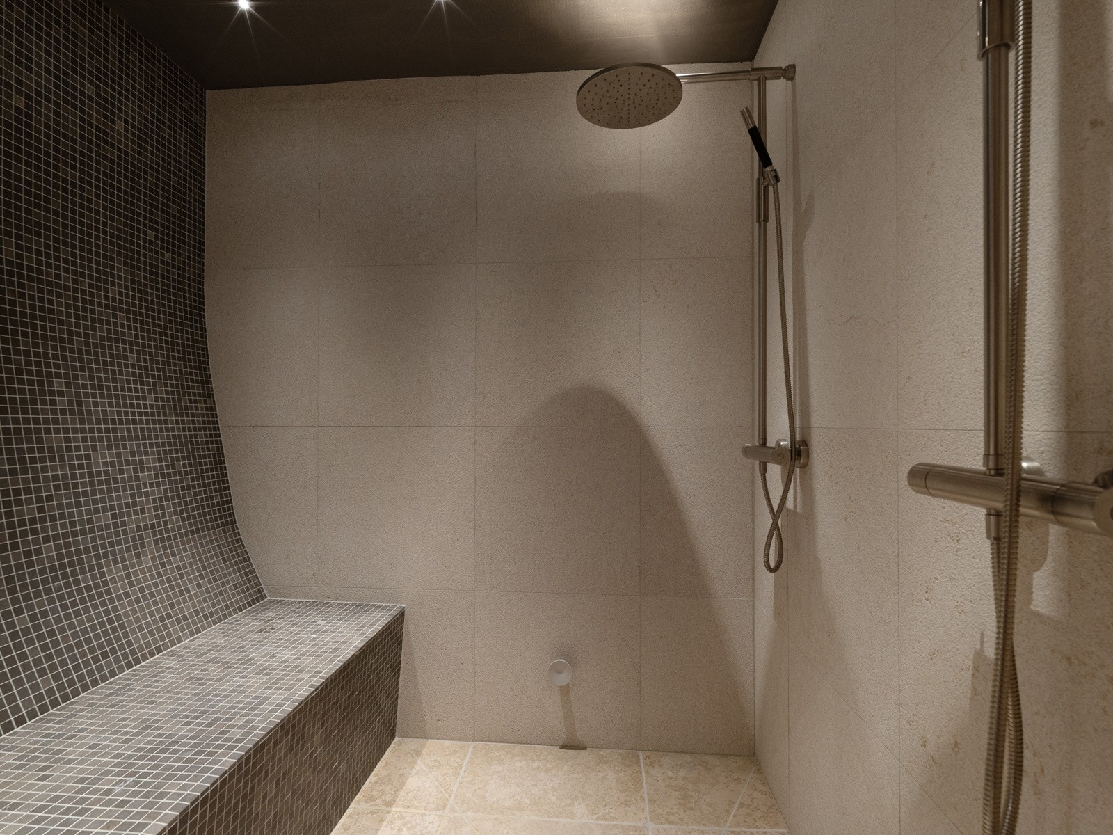 Lekkert flislagt dusjrom med doble dusjer med steamfunksjon og sittebenk. Galleribilde