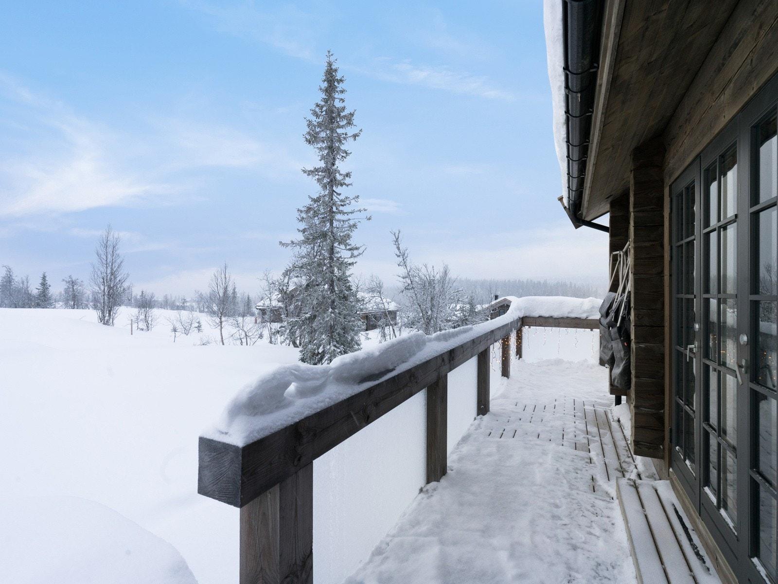 Terrasser med impregnerte gulvbord og underliggende membrantekking og rekkverk med trestolper og glassfelter. Galleribilde