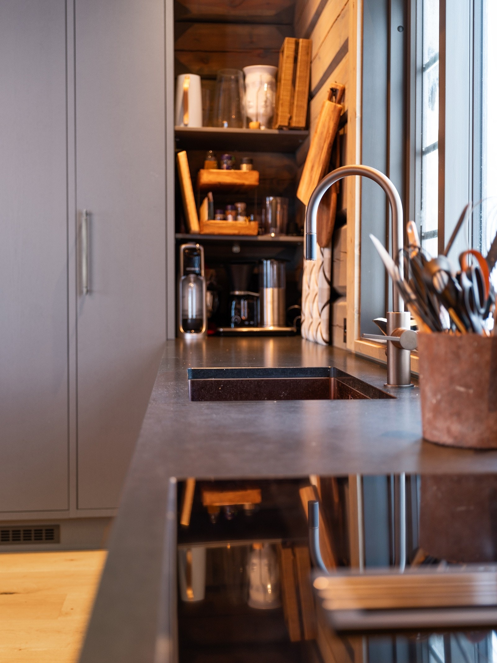 Benkeplanten av granitt med underlimt vaskekum og nedfelt keramisk induksjonstopp med integrert ventilator med avtrekk ut. Galleribilde