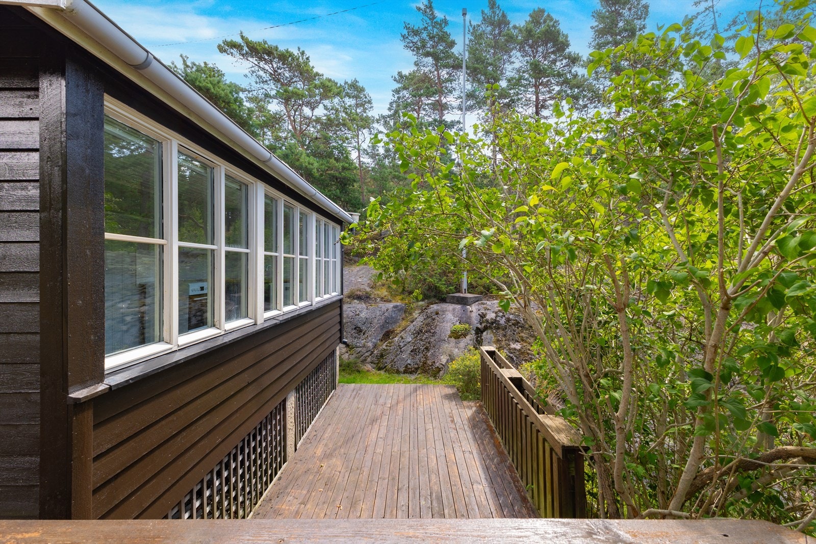 Utvendig byr hytta på en romslig sør-vestvendt veranda hvor familien kan nyte solfylte dager Galleribilde