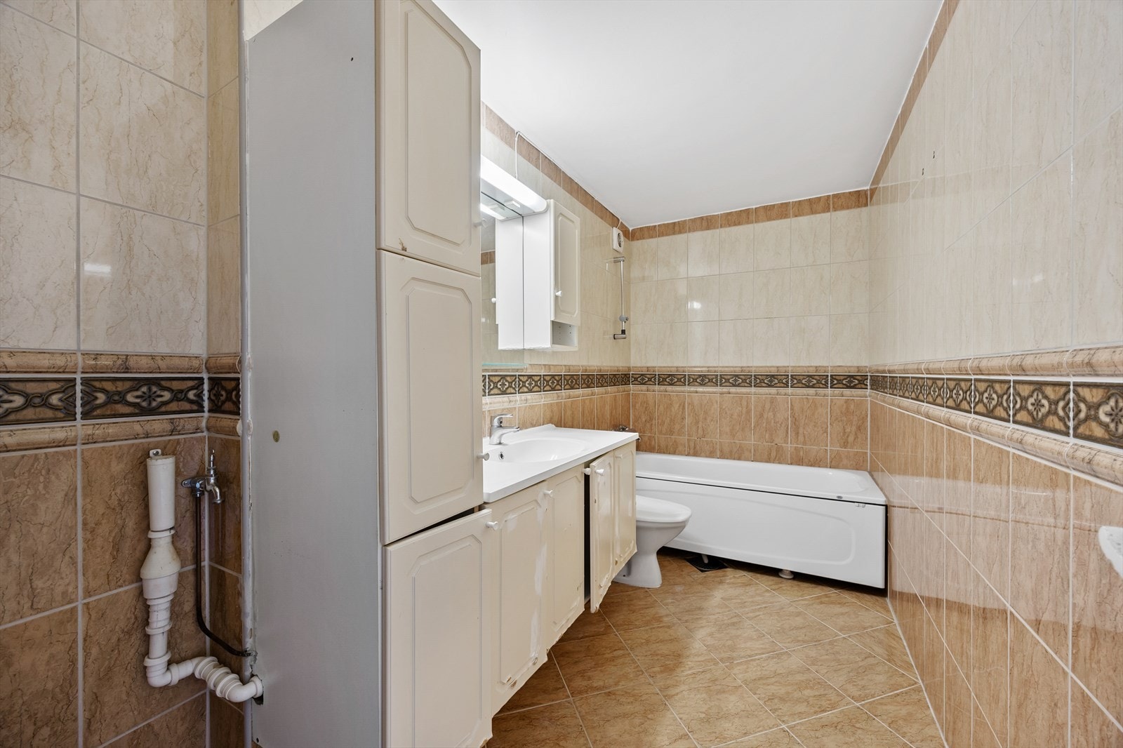 Stort baderom med varmekabler i gulvet og opplegg for vaskemaskin. Galleribilde