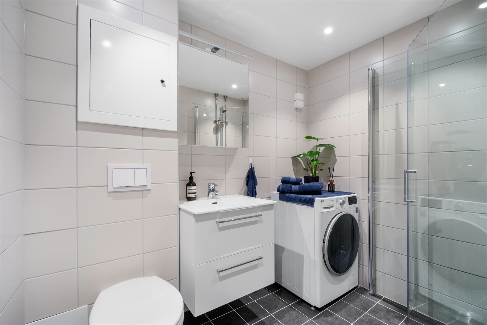 - Baderommet er innredet med vegghengt klosett, servant nedfelt i innredning, speilskap m/lys og dusjhjørne med svingbare glassdører. Opplegg for vaskemaskin. Naturlig avtrekk - Galleribilde