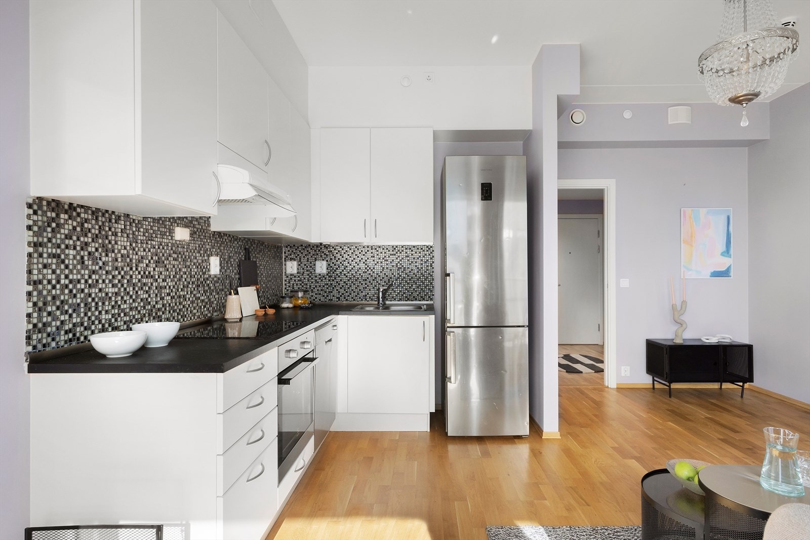 Kjøkkeninnredningen er fra byggeår bestående av slette, hvite fronter og laminat benkeplate Galleribilde