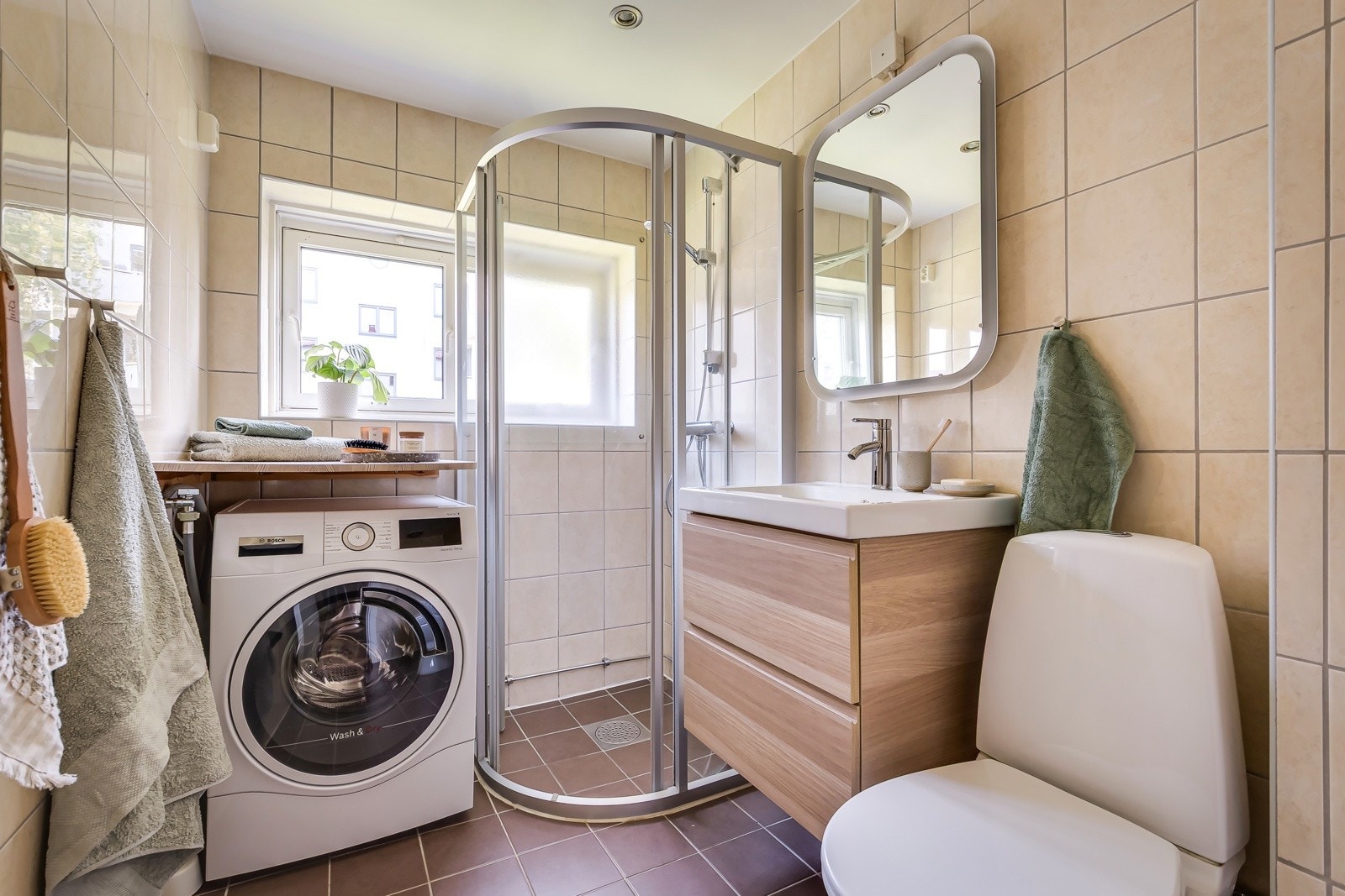 Rommet fremstår som lyst og pent, med en tidløs kombinasjon av mørke gulvfliser med behagelig gulvvarme og lyse veggfliser som gir et luftig og rent uttrykk. Galleribilde